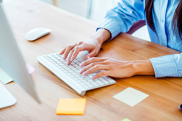 istock Young woman working on a computer in a bright office setting, showcasing professionalism and focus with a stylish and formal appearance 2207154322