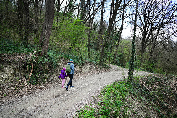 istock Father and daughter walking on a path in the woods 2207157123