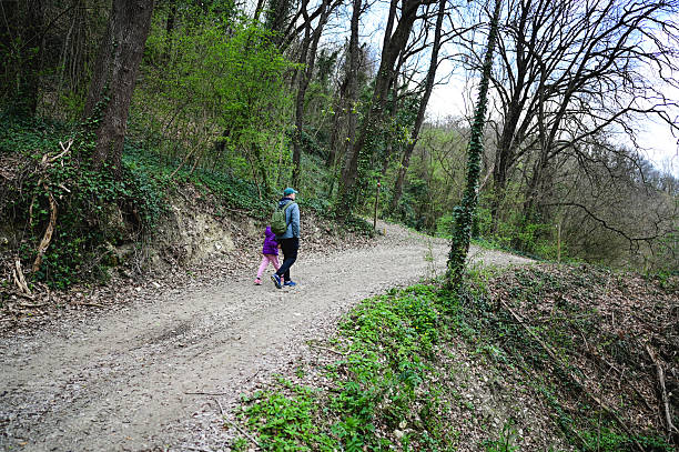 Father and daughter enjoying a leisurely walk through a peaceful forest trail