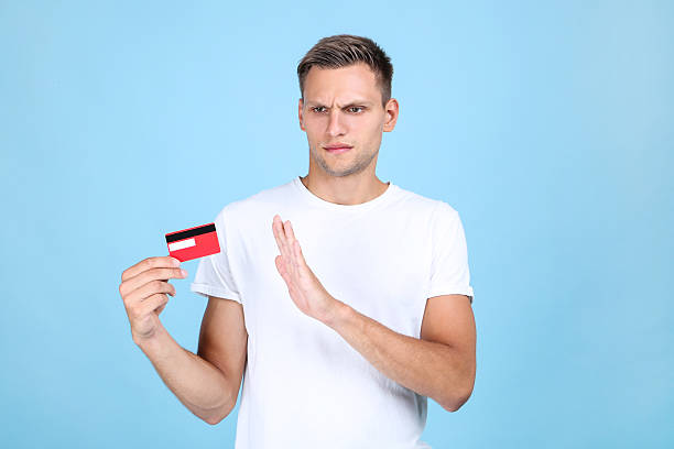 istock Young man holding credit card on blue background 2207157164