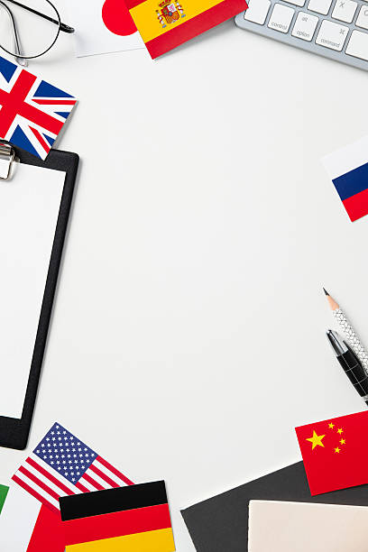 istock Office workspace with international flags, keyboard, clipboard, and stationery, ideal for global business, language school, or travel themes. Clean and professional aesthetic 2207161314