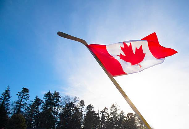 istock Canadian flag on hockey stick 2207162833