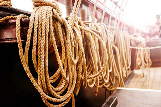 On the old pirate ships deck, ropes are meticulously looped against the sunlit backdrop