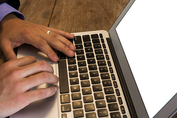 Laptop opened in bed of leaves with acorn on keyboard. Copy space provided by blank computer screen.