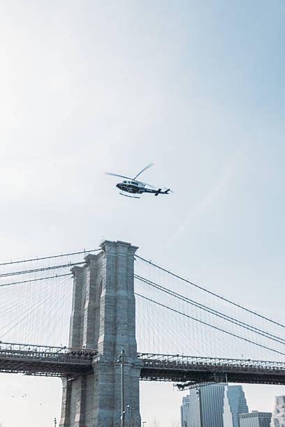 istock Helicopter Flying Over Iconic Bridge with City Skyline 2207170845