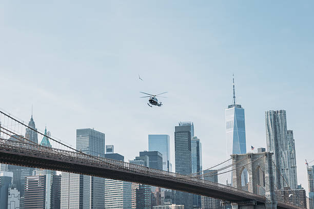 istock Helicopter Flying Over Iconic Bridge with City Skyline 2207170848