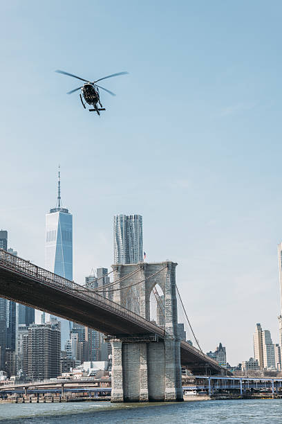 istock Helicopter Flying Over Iconic Bridge with City Skyline 2207170886