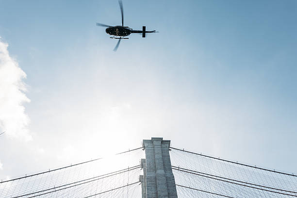 istock Helicopter Flying Over Iconic Bridge with City Skyline 2207170915