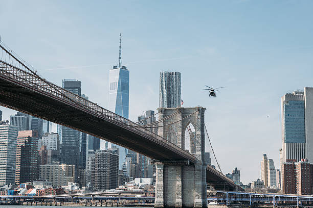 istock Helicopter Flying Over Iconic Bridge with City Skyline 2207170946