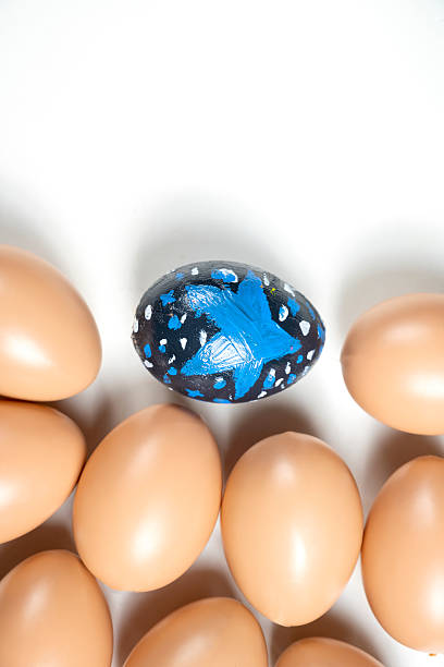 Top view of a colorful decorated easter egg surrounded by eggs on a white background. Concept of celebrating the easter holiday