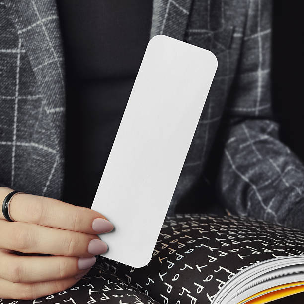 istock Woman holding a bookmark with rounded corners mockup 2207173536