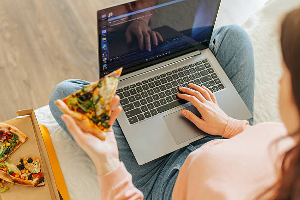 istock Enjoying pizza while working on a laptop at home during the afternoon 2207178816