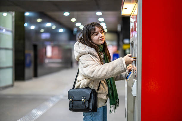 istock Young woman buying metro ticket from a machine 2207179739