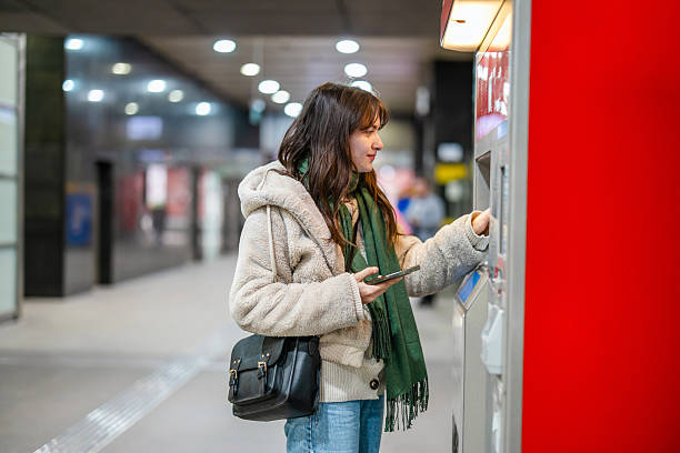 istock Young woman buying metro ticket from a machine 2207179744