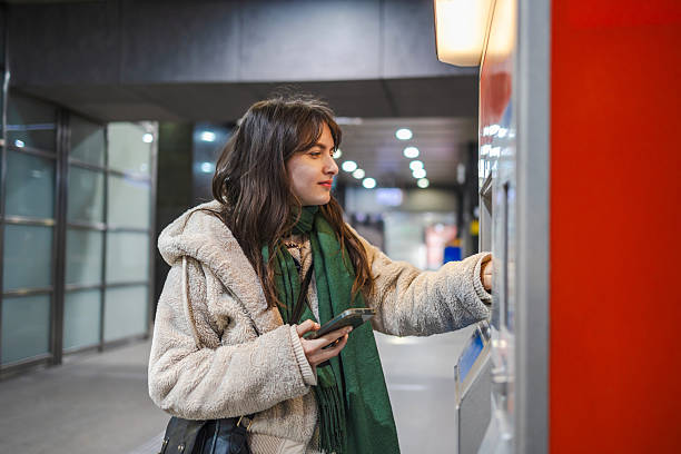 istock Young woman buying metro ticket from a machine 2207180323