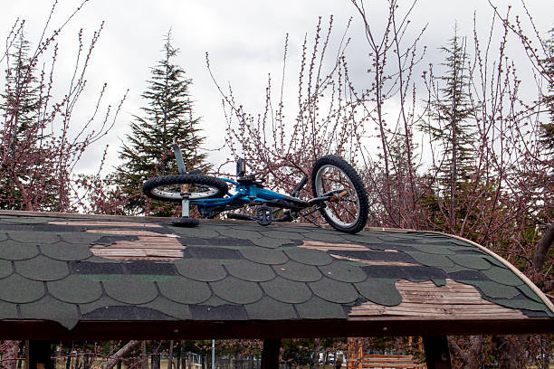 A male mountain bike rider does a no-hander off a jump in a dirt jump park.