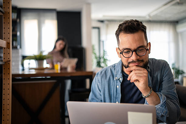 istock Focused freelancer working from home on laptop with partner in background 2207187266