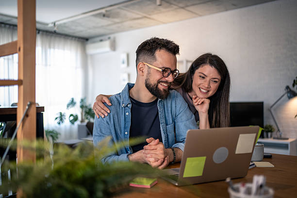 istock Young couple working from home looking at laptop 2207187585
