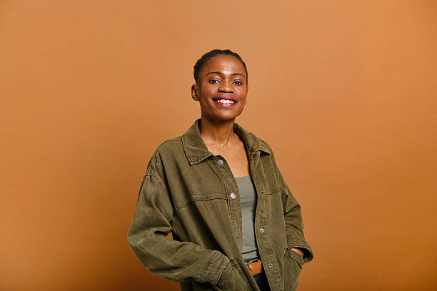 istock Young woman smiling with hands in pockets in studio portrait 2207188791