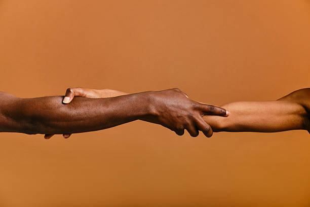 Studio shot of two arms gently holding each other, symbolizing connection and support