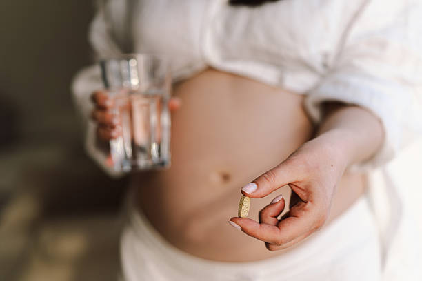 istock Pregnant young woman holding vitamins 2207189132