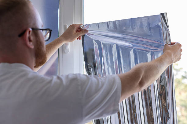 istock Man tinting windows at home with sun protection film. 2207189785