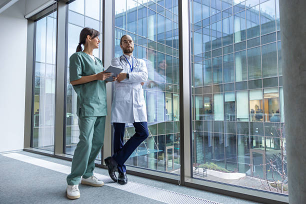 istock Two doctors discussing an interesting case while walking in the clinic corridor 2207190691