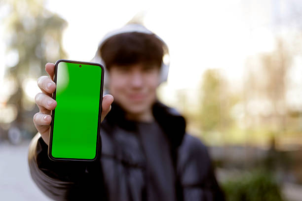 istock teenager showing cell phone screen to camera 2207191497