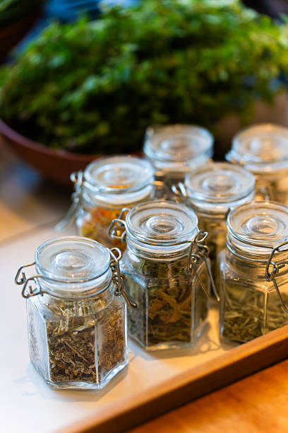 Glass jars filled with colorful spices and herbs, neatly organized on wooden shelves, creating a vibrant and aromatic display