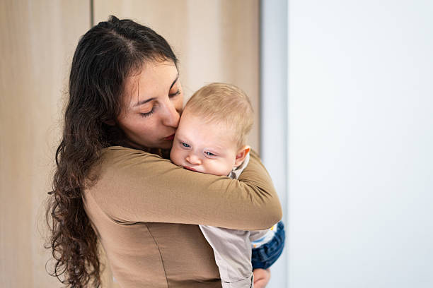 istock Mother embracing her baby with love 2207192387