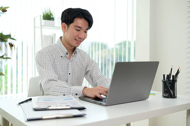 istock Young entrepreneur analyzing financial data on laptop and planning strategy at modern office. 2207192707