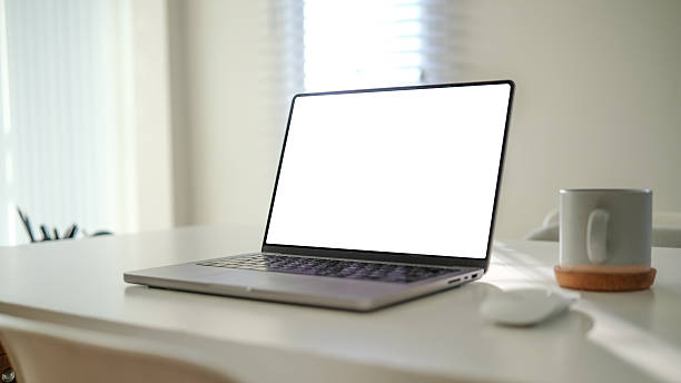 istock Contemporary office setup with a laptop displaying a blank screen, a warm coffee mug, and a neat workspace. 2207193174