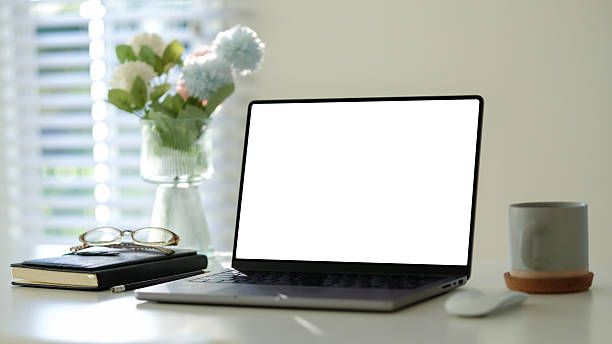 istock Minimalist home office featuring an open laptop, a coffee mug, and a journal on a tidy desk. 2207193186