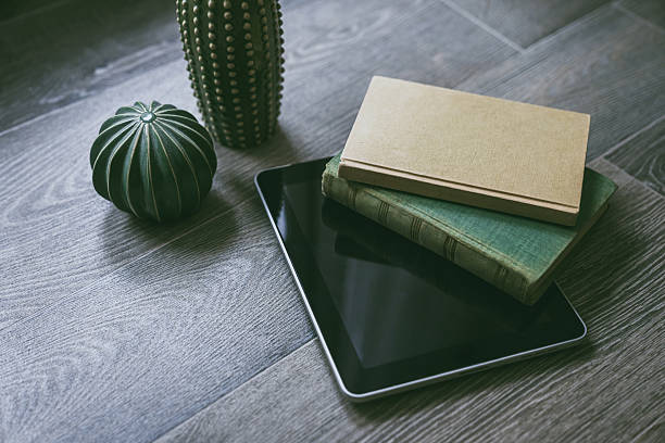 istock Traditional vs digital reading. Two paper books beside a modern tablet on a wood surface, Evolution of literature, information access concept. Ideal for articles on reading, technology, or education. 2207193971