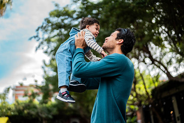 istock Young father playing with baby son outdoors 2207194113