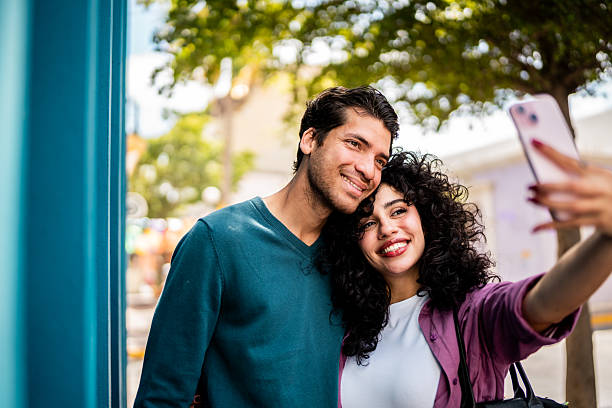 istock Young couple taking a selfie outdoors 2207195499