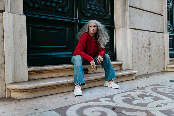 istock Stylish senior woman sitting on steps in urban setting 2207195965