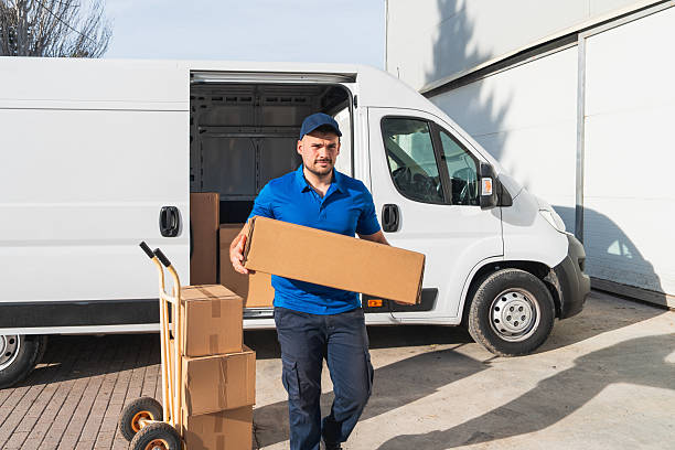 istock Delivery Worker Carrying Package from Van on Sunny Day 2207198880
