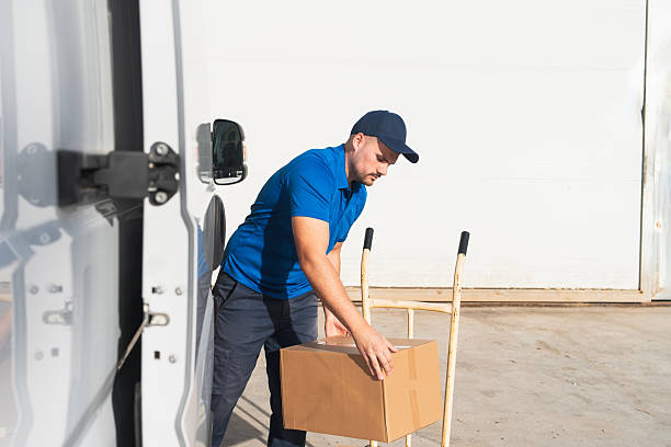 istock Courier Loading Cardboard Box on to Hand Truck 2207198890