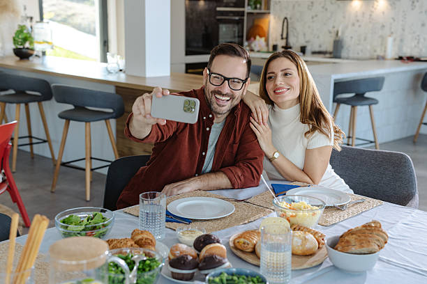 istock Smiling couple taking a selfie together in a cozy modern dining space 2207200181