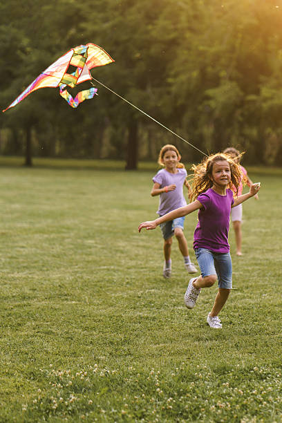 istock Children run with a kite during summer day in the park 2207200221