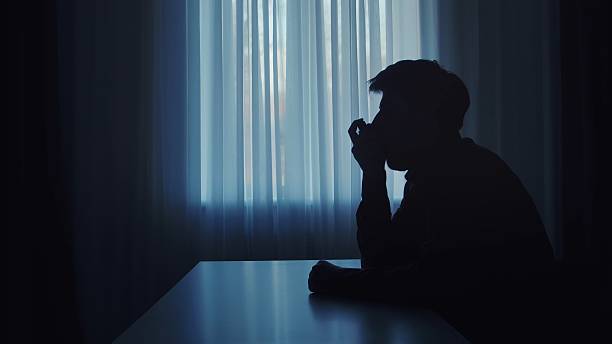 istock Dark silhouette of a man inhaling asthma aerosol. 2207201521