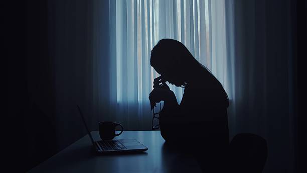 istock Silhouette of a Woman in Thought in Front of Computer 2207201731