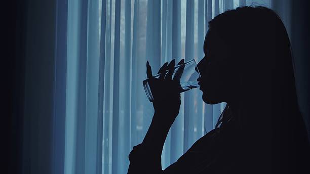 istock Silhouette of Person Drinking Water in Soft Light 2207201896