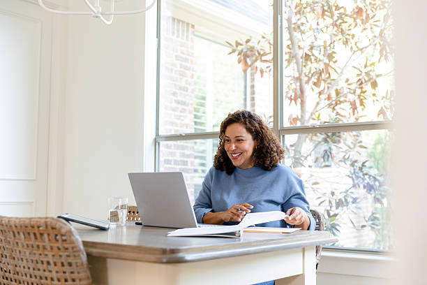 istock Hispanic Woman Working From Home on Laptop, Smiling 2207202061