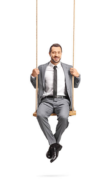 istock Businessman sitting on a swing and smiling 2207203064