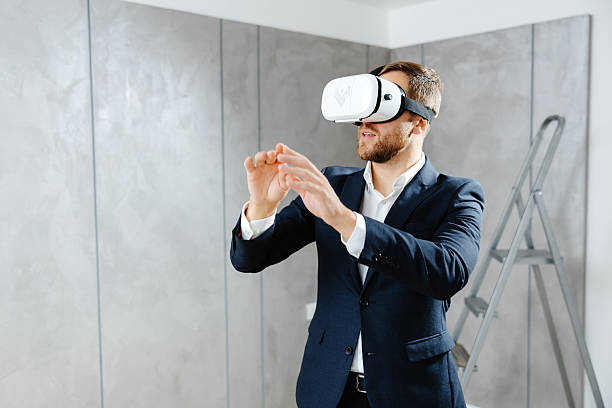 istock Young man wearing VR glasses, scrolling with hands in air using futuristic innovative technology choosing home design. Repair and renovation concept. Virtual reality 2207205651