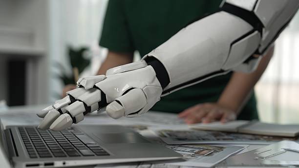 istock Robotic Arm Assisting Human in Modern Workspace with Laptop Technology 2207209304