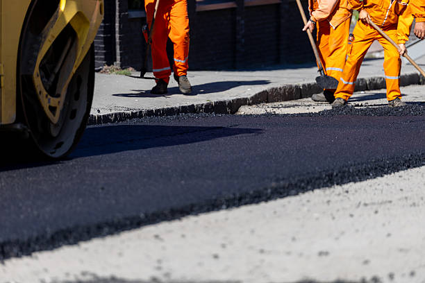 istock Construction workers laying asphalt on a city street in broad daylight 2207209904
