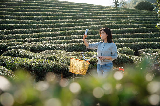istock asian female selfie with smart phone while outding with bike 2207210604
